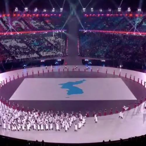 Onder gezamenlijke vlag lopen Koreaanse atleten het stadion binnen